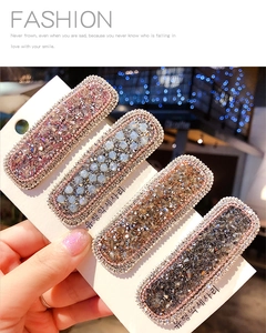 Close-up of a four-piece set of sparkling crystal rectangle hair clips in mixed colors