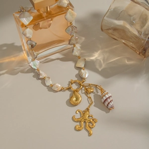 Close-up of ocean-themed necklace with golden octopus and real shell charms on a pearl bead chain