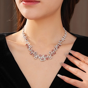 Macro detail of vintage floral necklace with red oval gems and sparkling clear zircons