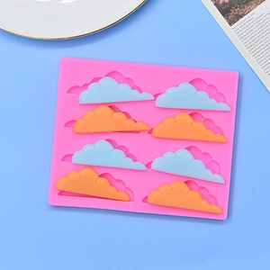Detailed view of 8-cavity cloud silicone mold with blue and orange fondant cloud samples