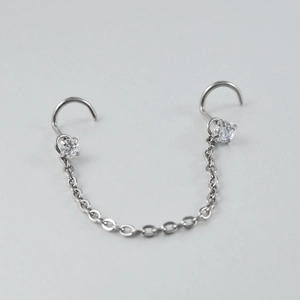 Detail view of G23 titanium double nose stud with silver chain and clear zircon stones
