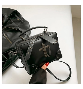 Detail of gothic punk box bag with metal cross pendant, silver chains and rivets