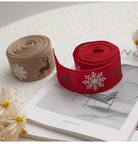 Close-up of Christmas jute ribbons with reindeer and snowflake prints in red and natural beige