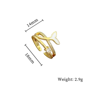 Detail view of gold geometric fishtail open ring with cubic zirconia and white enamel