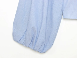 Macro view of blue and white striped poplin shirt sleeve with elastic cuff detail