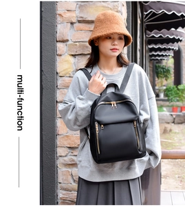 Close-up of black nylon backpack with golden zippers on a stylish female model outdoors