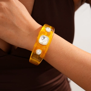 Detail of amber resin bangle with crystal embellishments and vintage geometric design