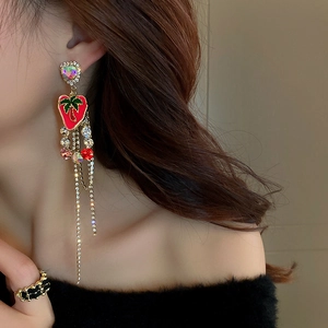 Detail of elegant butterfly tassel earrings with rainbow heart crystals worn by model