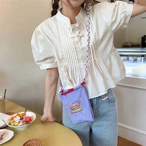 Close-up of carousel embroidery on a purple oxford fabric crossbody phone bag