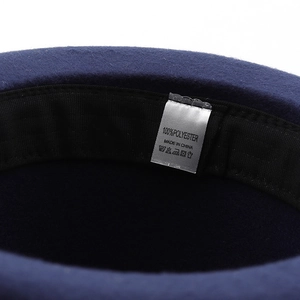 Macro view of inner polyester lining with high-quality stitching and care label on navy fedora