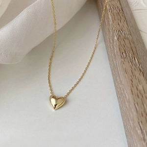 Classic 18K gold plated 925 sterling silver heart pendant necklace on white fabric