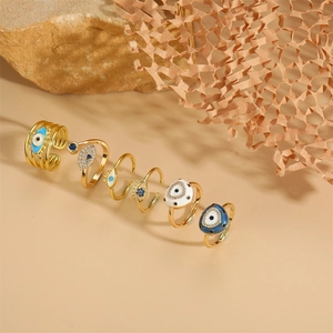 Set of six gold Evil Eye rings with blue enamel and zircon stones in a boho style