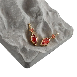 18k gold plated earring setting with red marquise cut zircon on grey rock background
