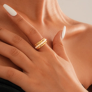 Close-up of gold plated hollow-out open ring with white pearls on model finger
