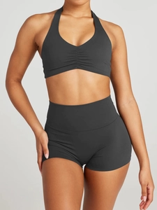 Detail of dark grey halter sports bra with ruched chest design and high waist gym shorts