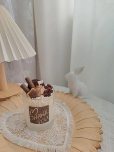 Close-up of strawberry chocolate dessert candle with bear and biscuit wax toppers