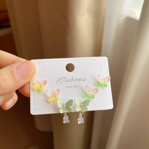 Detailed view of three pairs of silver 925 butterfly stud earrings with colorful sequins