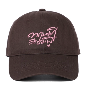 Detailed close-up of pink embroidery on a washed cotton dark coffee baseball cap