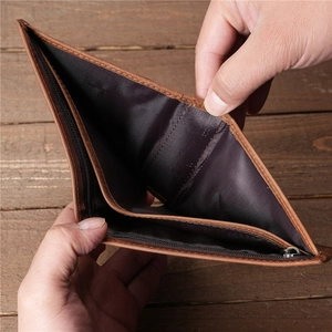 Detail of brown leather wallet interior showing zipper compartment and card slots