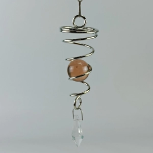 Detailed view of silver metal spiral cage with brown bead and faceted crystal prism