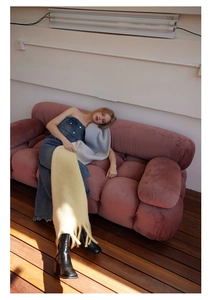 Fashion model wearing light blue and yellow wool fringe scarves in a warm loft setting