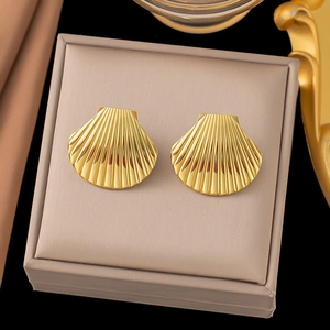 Elegante goldene Ohrringe in Muschelform präsentiert in einer beigen Schmuckschatulle
