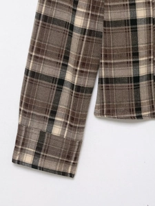 Close-up of brown and beige plaid shirt fabric texture and premium stitching detail