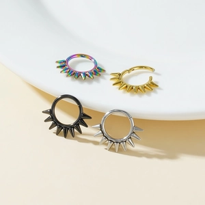 Detailed macro view of four punk spike earrings in black, gold, silver, and rainbow steel