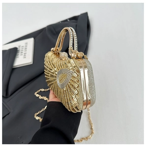 Detail view of gold sequin evening clutch featuring crystal handle and metallic frame