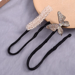 Close-up detail of pearl and butterfly bun makers for elegant vintage hairstyling.