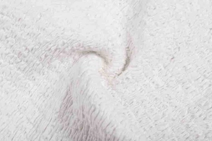 Gros plan sur la texture du tissu polaire rose montrant l'épaisseur et la matière douce