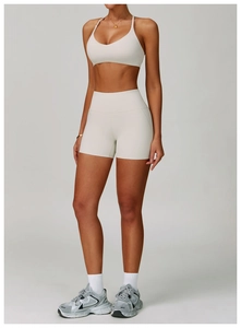 Close-up of beige sports set with halter v-neck bra and high waist biker shorts