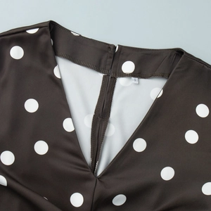 Détail du col en V d'une robe noire à pois avec découpe arrière et étiquette taille S