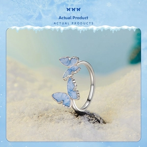 Detailed close-up of S925 sterling silver butterfly ring with blue marble wings in snow scene
