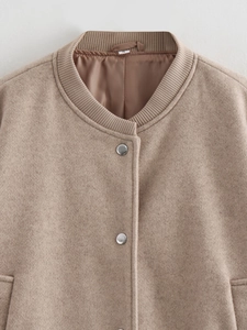 Detail of camel wool jacket showing ribbed collar, metal snap buttons and fabric texture