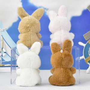 Back view of four cute plush rabbit keychains in various colors on a display stand