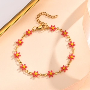 Detailed shot of golden chain bracelet with pink enamel daisy charms and lobster clasp