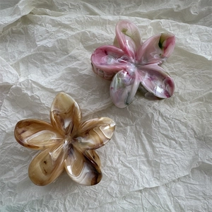 Detailed close-up of marble pattern flower hair claw clips with high-gloss acetate finish