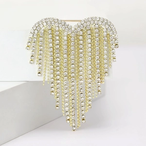 Detail of luxury heart brooch featuring gold metal tassels and sparkling rhinestones