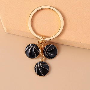Close-up of alloy basketball keyrings with black enamel charms and gold-tone finish