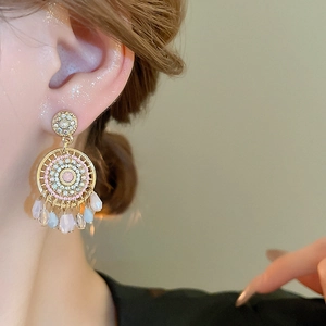 Bohemian dreamcatcher tassel earrings with pink rhinestones and colorful beads on model