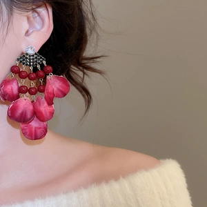 Detail of vintage red fabric petal tassel earrings with crystals on a female model