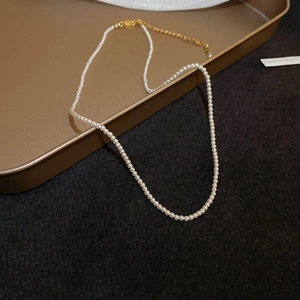 Close-up of elegant pearl necklace with gold lobster clasp and adjustable chain link