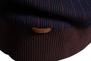 Close-up of blue and brown striped knit sweater featuring a premium leather brand patch
