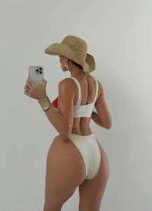 Side view of white bikini set with red flower prints and elegant straw hat detail