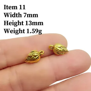 Detailed view of two small antique gold peanut pendants with leaf veins and dimensions