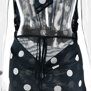 Détail du design dos nu à lacets sur une mini robe sexy noire à pois blancs
