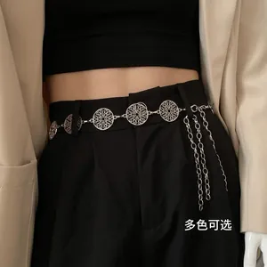 Silver hollow circle waist chain with layered tassels over a suit and black pants
