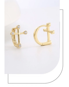 Macro shot of S925 sterling silver cross earrings plated in 14K gold with cubic zirconia