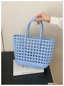Close-up of light blue hollow woven jelly bag held by a model for summer vacation style